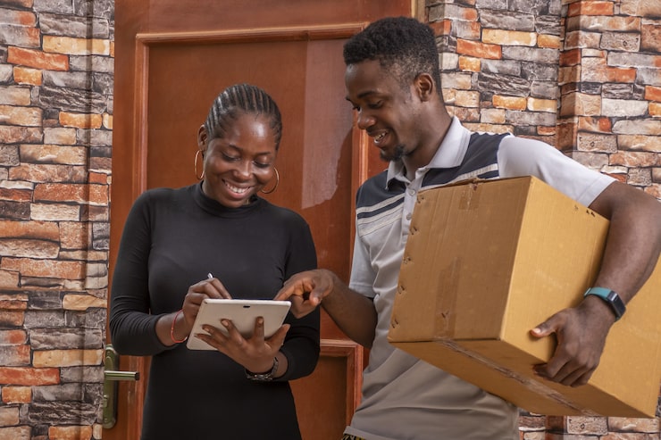 african-female-signing-proof-delivery-while-receiving-parcel-from-courier_181624-41714
